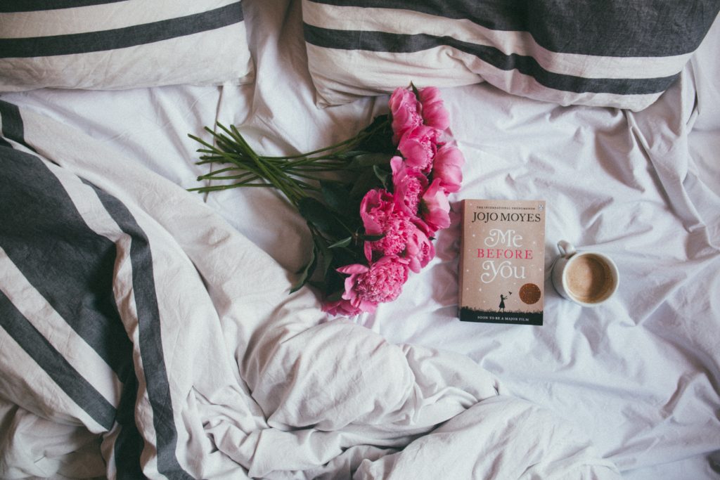 flowers, book, and coffee in bed